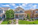 An inviting two-story home with a lovely front yard and a charming, covered front porch at 21392 E Stroll Ave, Parker, CO 80138