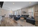 Bright living room featuring a modern sectional sofa, elegant lighting, and wood-style flooring at 21392 E Stroll Ave, Parker, CO 80138