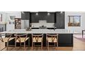 Bright open kitchen features a large island with counter seating and sleek black cabinets at 4454 Utica St, Denver, CO 80212