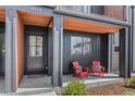 Inviting porch with stylish black exterior accents and cozy red Adirondack chairs at 4454 Utica St, Denver, CO 80212