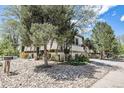 A multi-level home with mature trees, unique architectural details, and rock landscaping at 9349 E Chenango Ave, Greenwood Village, CO 80111