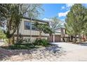 A multi-level home with mature trees, unique architectural details, and a large driveway at 9349 E Chenango Ave, Greenwood Village, CO 80111