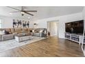 Spacious living room with wood flooring, large sectional sofa, and a ceiling fan at 176 W Elm St, Elizabeth, CO 80107