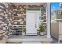 Charming front porch with stone accents, a white door, and stylish potted plants adding to the curb appeal at 4060 N Rome St, Aurora, CO 80019