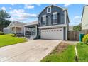 Two-story home with blue siding, white garage door, and a driveway and yard at 9816 Garwood St, Littleton, CO 80125