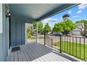 Cozy front porch with hanging flower basket and black metal railing at 9816 Garwood St, Littleton, CO 80125