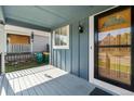 Charming porch with blue siding, white trim, and a decorative glass front door at 9816 Garwood St, Littleton, CO 80125