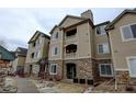 Attractive condo building with stone accents, balconies, and well-maintained landscaping at 8369 S Independence Cir # 205, Littleton, CO 80128