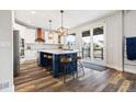 Bright kitchen boasts a stylish island with seating, modern pendant lights, and stainless steel appliances at 10039 Heatherwood Pl, Highlands Ranch, CO 80126