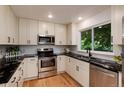 Updated kitchen boasts black countertops, white cabinets, and stainless steel appliances at 8543 Redstone St, Highlands Ranch, CO 80126
