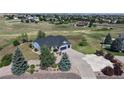 An aerial view showcases this home's premium lot with a large driveway, mature trees, and lush green space at 14701 Yosemite St, Brighton, CO 80602