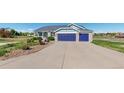 Home exterior with a two-car garage, well-maintained lawn, and garden, set back from a long driveway at 14701 Yosemite St, Brighton, CO 80602