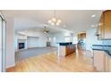 Spacious living room featuring a fireplace, hardwood floors, and an open layout to the kitchen at 14701 Yosemite St, Brighton, CO 80602