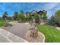 Two-story home with manicured front lawn and a stone pillar displaying the house number at 5428 Forest View Rd, Parker, CO 80134