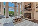 Bright living room featuring a stone fireplace, soaring ceilings, and expansive windows with natural light at 5428 Forest View Rd, Parker, CO 80134