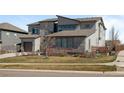Attractive modern home with a combination of stone and siding, a well-maintained lawn, and mature trees at 8172 S Langdale Way, Aurora, CO 80016
