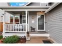 Inviting front porch featuring white railings, a cozy porch swing, and decorative accents, creating a welcoming entrance at 21733 Saddlebrook Dr, Parker, CO 80138