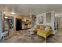 Open living space with a modern kitchen, yellow sofa, and unique tile floors at 1243 Gaylord St # 410, Denver, CO 80206