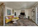 Cozy living room featuring unique tile floors, a comfortable yellow sofa, and ample natural light at 1243 Gaylord St # 410, Denver, CO 80206