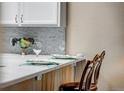 Quartz countertops with gray backsplash on kitchen counter with seating at 2428 W 82Nd Pl # 1D, Westminster, CO 80031