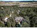 Aerial view of a house nestled in a wooded area at 8174 Inca Rd, Larkspur, CO 80118