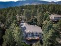 House with large deck, nestled in a wooded, mountainous area at 8174 Inca Rd, Larkspur, CO 80118