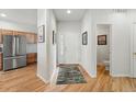 Bright entryway featuring hardwood floors, white walls and an adjacent powder room at 3548 W 126Th Pl, Broomfield, CO 80020