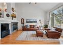 Inviting living room with a fireplace, large windows, and vaulted ceilings at 3548 W 126Th Pl, Broomfield, CO 80020