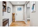 Cozy entryway with hardwood floors, a white front door, and decorative wall art at 14290 W 54Th Ave, Arvada, CO 80002