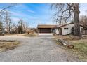 Charming single-story home with a stone and painted brick facade, a large driveway and an attached two-car garage at 14290 W 54Th Ave, Arvada, CO 80002