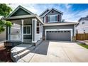 Suburban home with a charming front porch and a two-car garage, complete with a well-maintained driveway at 5794 S Yakima Way, Aurora, CO 80015
