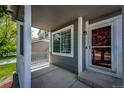 Cozy front porch features white pillars, a window, and a door, creating a welcoming entrance at 5794 S Yakima Way, Aurora, CO 80015