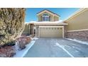 Tan two-story home with stone accents and a two-car garage; snow on the ground at 22991 E Roxbury Dr # B, Aurora, CO 80016