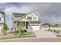 Charming two-story home featuring a two car garage, inviting porch, and manicured front yard at 27655 E Geddes Pl, Aurora, CO 80016