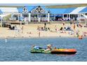 People enjoy waterfront activities in front of beach buildings with blue roofs and white awnings at 27655 E Geddes Pl, Aurora, CO 80016