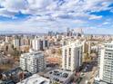 An aerial view shows a high-rise condominium complex in an urban setting with mountain views at 777 N Washington St # 204, Denver, CO 80203