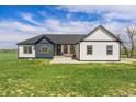 Charming farmhouse exterior with blue and white siding, arched windows, and a welcoming front porch at 2400 Ventress Ct, Bennett, CO 80102