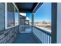 Covered front porch with stone accents and gray railings looking out at the neighborhood street at 17412 Rose Mallow St, Parker, CO 80134