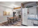 Open-concept dining room featuring wood floors and exposed brick detail, creating a cozy atmosphere at 12211 E Arkansas Pl, Aurora, CO 80012