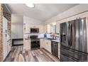 Bright kitchen with stainless steel appliances, updated countertops, and new flooring at 12211 E Arkansas Pl, Aurora, CO 80012