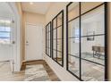 Inviting entryway featuring wood floors and large decorative mirrors reflecting natural light into the home at 13838 Honey Hush Trl, Parker, CO 80134