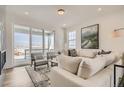 Bright living room with a comfortable sofa, chairs, and a sliding glass door leading to a balcony at 13838 Honey Hush Trl, Parker, CO 80134