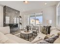 Cozy living room with a fireplace, comfortable seating, and a view to the outside balcony at 13838 Honey Hush Trl, Parker, CO 80134