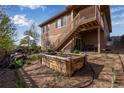 Outdoor patio and backyard with a nice garden, outdoor seating, grill, and stair access to a deck above at 4000 Donnington Cir, Castle Rock, CO 80104