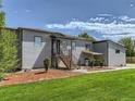 Two-story home boasts an open staircase to the front door and mature landscaping at 10197 E Mississippi Ave, Denver, CO 80247