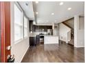 Open-concept kitchen featuring dark cabinets, stainless steel appliances, and hardwood flooring at 16075 E Elk Pl, Denver, CO 80239