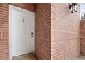 Close up of a white front door with a digital lock and a brick facade at 4001 W 32Nd Ave # 1, Denver, CO 80212