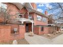 Brick exterior featuring a white covered balcony and black metal fencing at 4001 W 32Nd Ave # 1, Denver, CO 80212