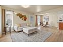 Cozy living room featuring a sofa, ottoman, and stylish decor at 21422 E 47Th Ave, Denver, CO 80249
