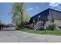 Exterior view of a townhome with a well-maintained lawn and nearby garages at 6844 S Broadway, Littleton, CO 80122